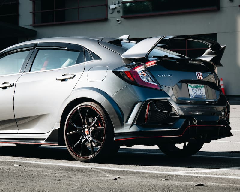 Szara Honda Civic Type R z tylnym spojlerem zaparkowana na zewnątrz.