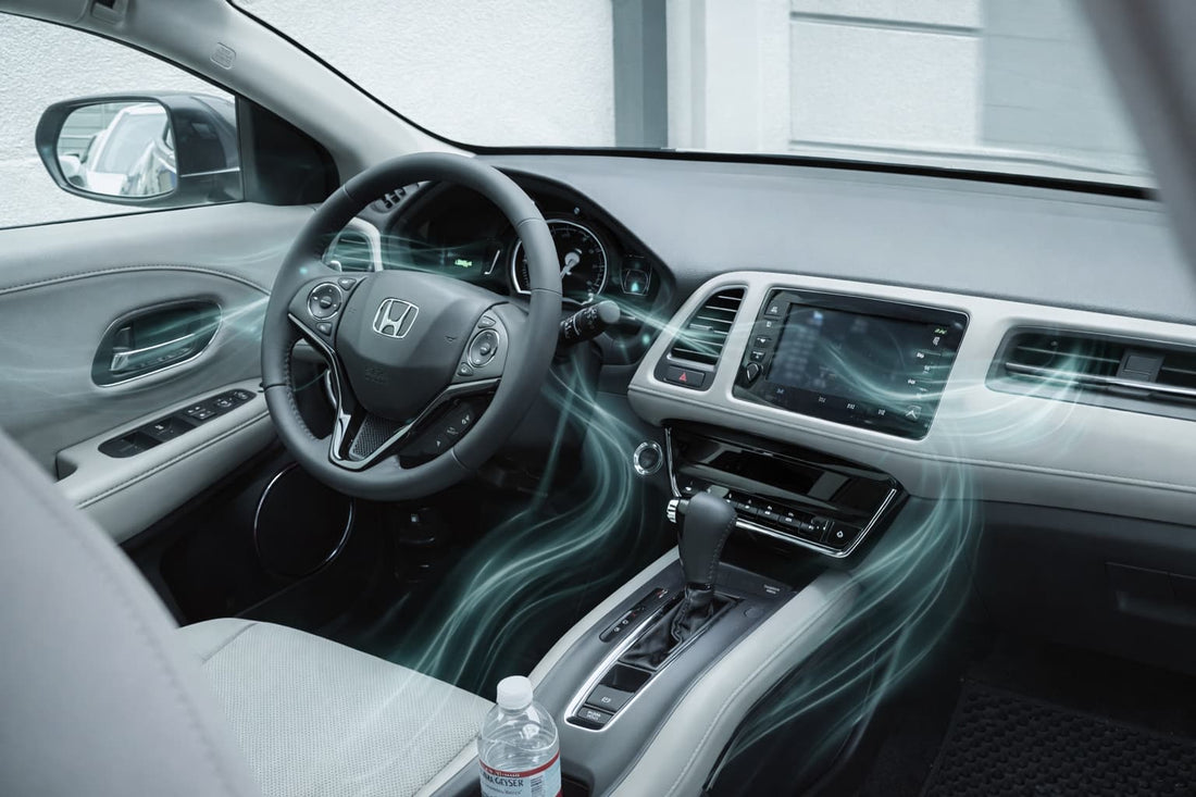 Wnętrze auta z deską rozdzielczą i nawiewami pokazujące przepływ powietrza w kabinie.