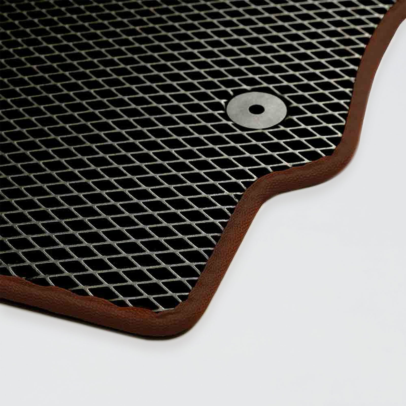 A black rubber car mat with a brown border and a circular metal fastener